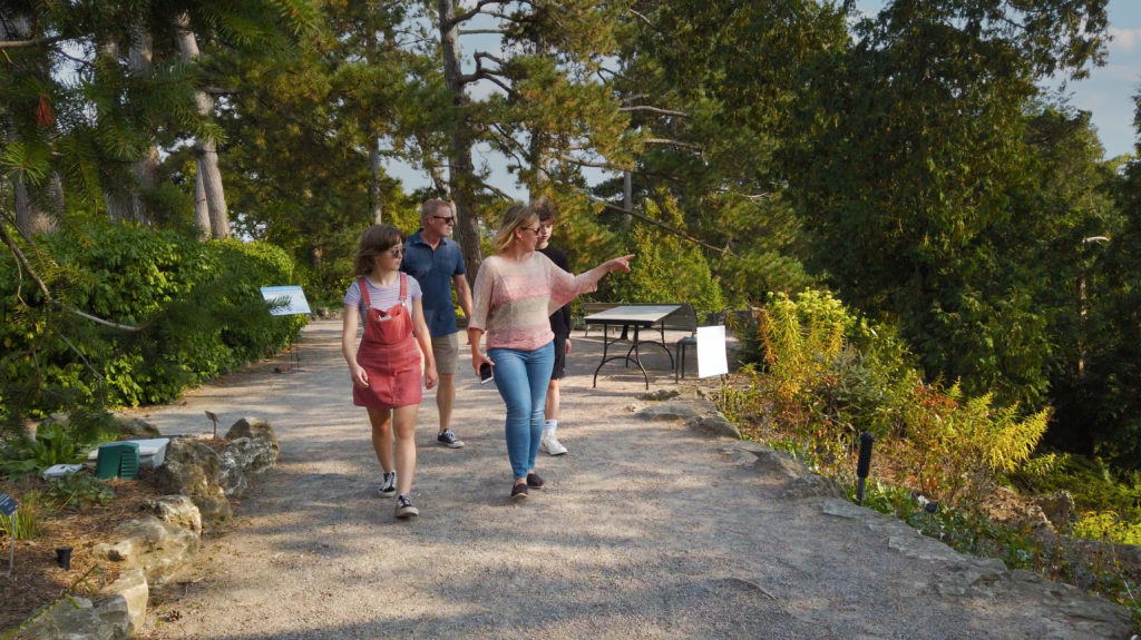 Mom, Dad, boy and girl walking on path in the Rock Garden at RBG, Mom is pointing to something and everyone is looking